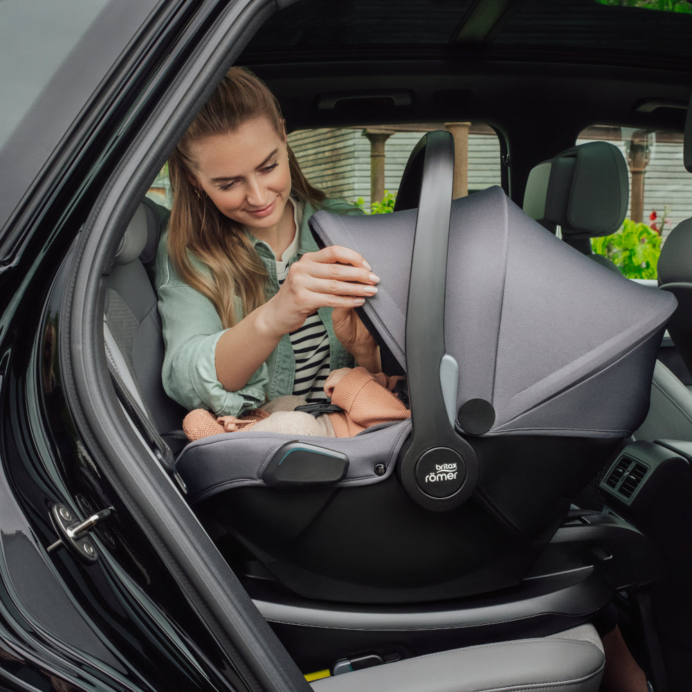 Mum in car with baby in Britax Römer Baby-Safe Core infant carrier car seat in midnight grey, on ISOfix base