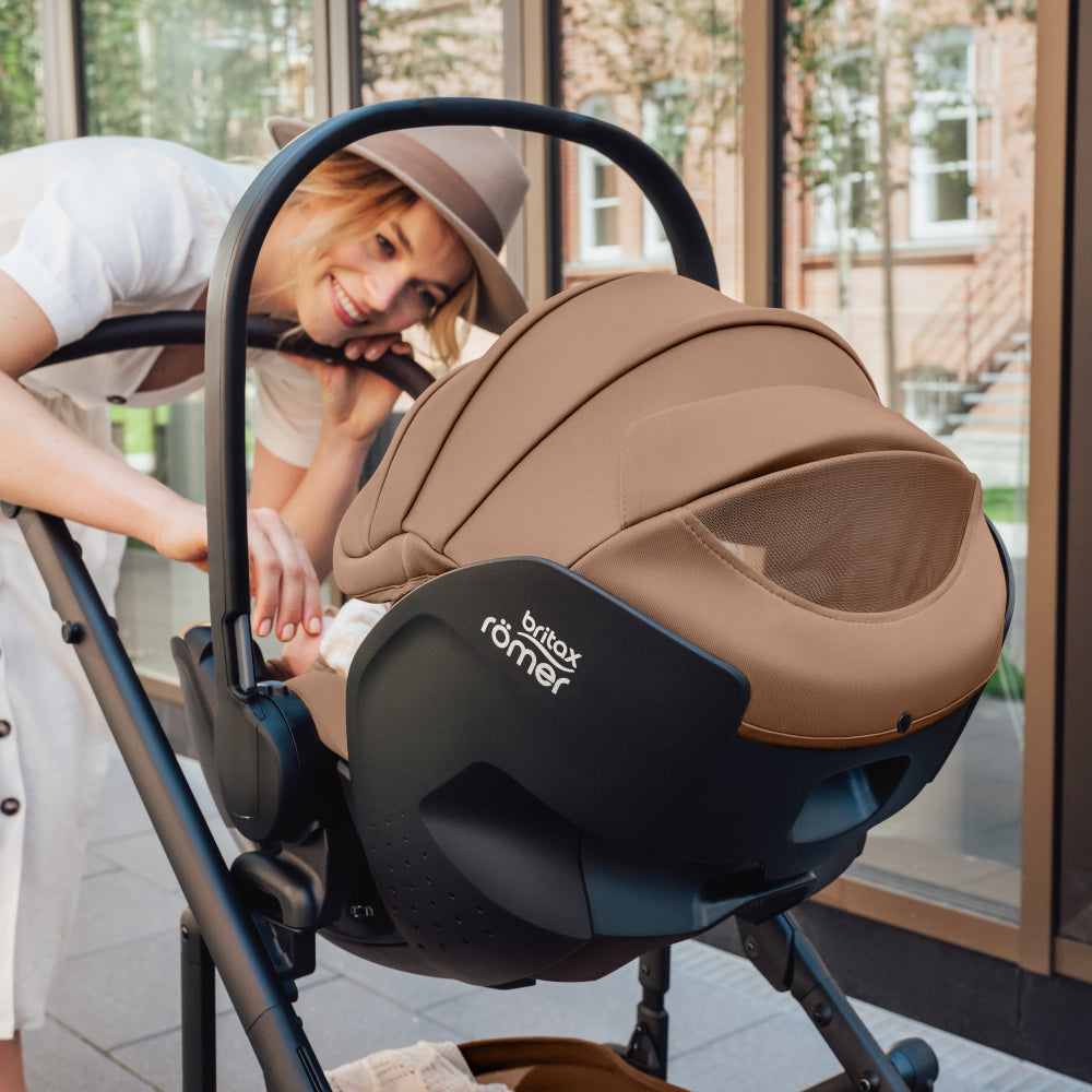 Mum with baby in Britax-Römer Baby-Safe Pro infant carrier car seat in Warm Caramel on Smile III pushchair