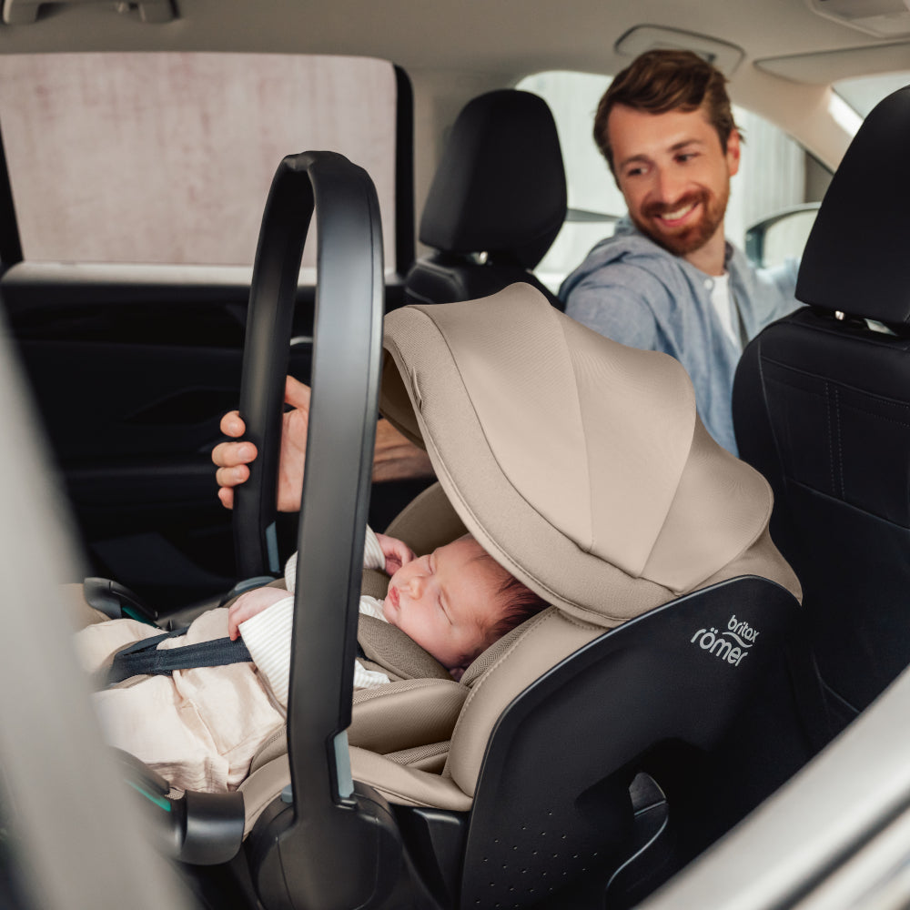 Dad in car with baby in Britax-Römer Baby-Safe Pro infant carrier car seat in Teak on Vario 5Z ISOfix base