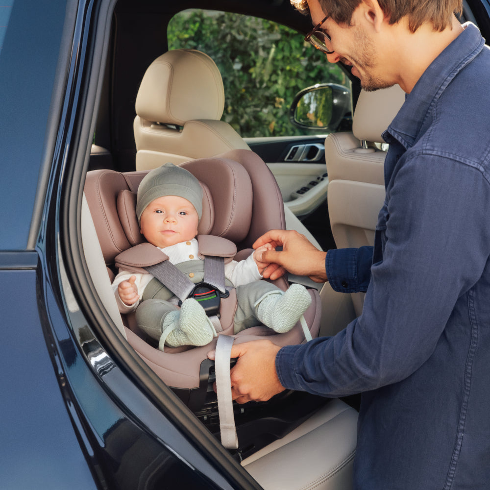 Britax-Römer Swivel ISOfix rear facing car seat in Dusty Rose, baby in car with dad