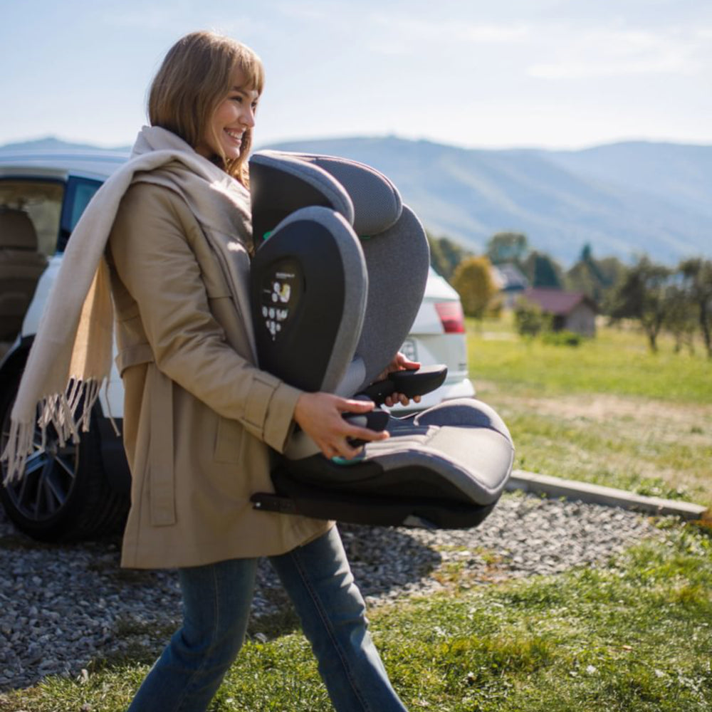 Avionaut MaxSpace AirFlow High Back Booster Seat Grey woman carrying outside near car