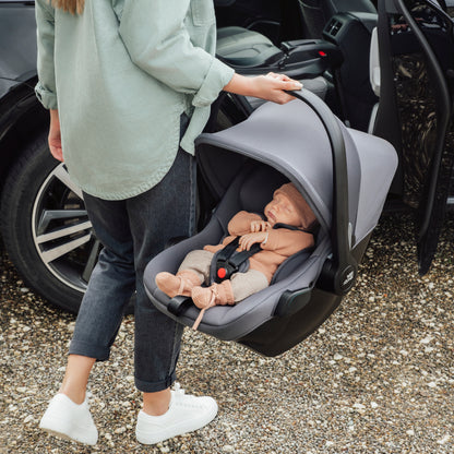 Mum carrying baby in Britax Römer Baby-Safe Core infant carrier car seat in midight grey