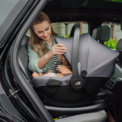 Mum in car with baby in Britax Römer Baby-Safe Core infant carrier car seat in midnight grey, on ISOfix base