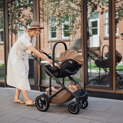 Mum pushing baby in Britax-Römer Baby-Safe Pro infant carrier car seat in Warm Caramel on Smile III pushchair