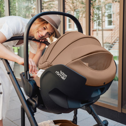 Mum with baby in Britax-Römer Baby-Safe Pro infant carrier car seat in Warm Caramel on Smile III pushchair