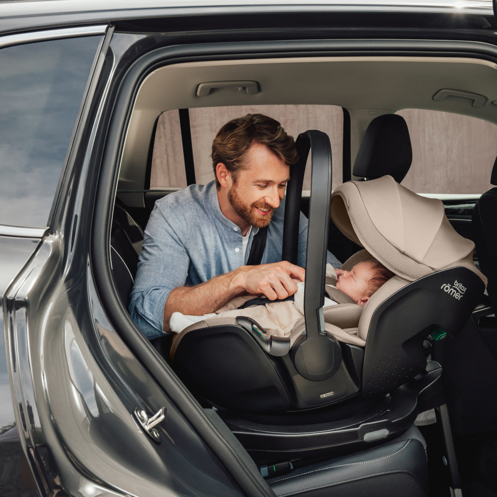 Dad in car with baby in Britax-Römer Baby-Safe Pro infant carrier car seat in Teak on Vario 5Z ISOfix base