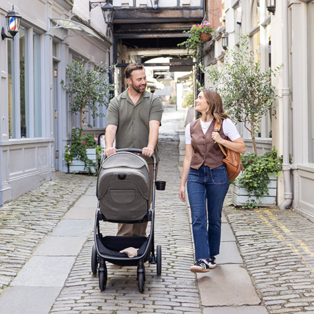 Mum and dad pushing Joie Finiti Pushchair Evergreen