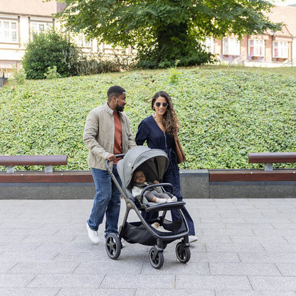 Couple pushing baby in Joie Finiti Pushchair Evergreen